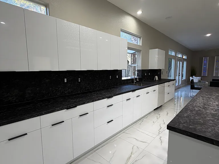 Alternate view of the contemporary kitchen showcasing expansive cabinetry and granite countertops.