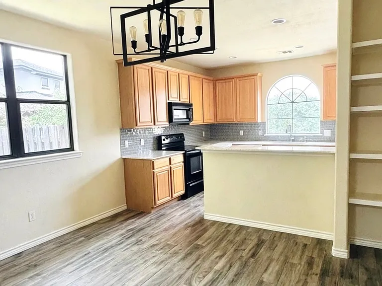 Open dining area, modern lighting, built-in shelving, breakfast bar
