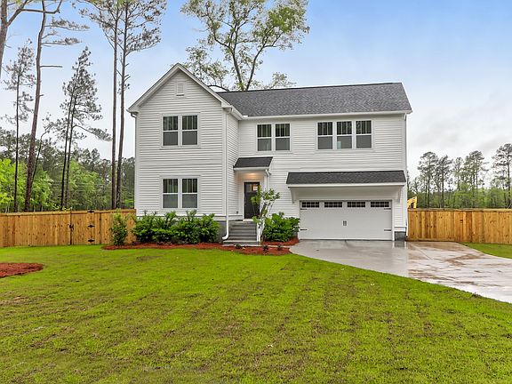 A white house with a wooden fence in front of it