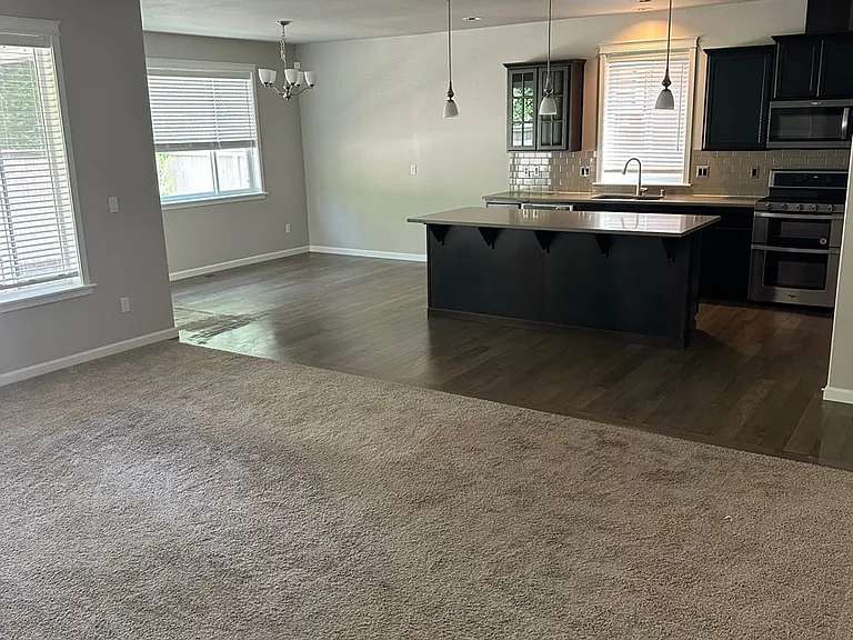 open concept living room, dining room, kitchen. Sliding door leads to backyard.