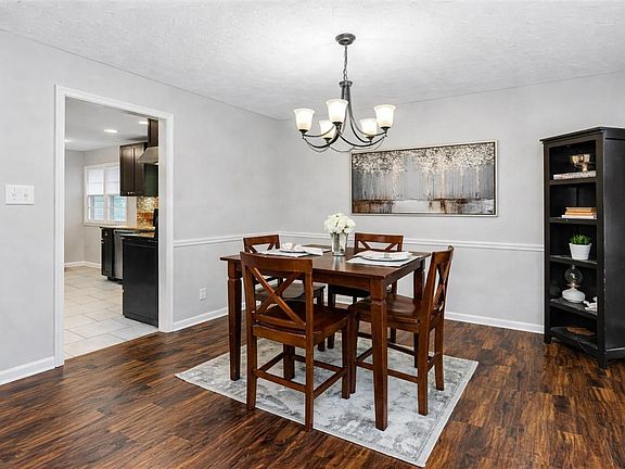 Dedicated dining room with chandelier lighting, wood flooring, and easy access to the kitchenideal for everyday meals.