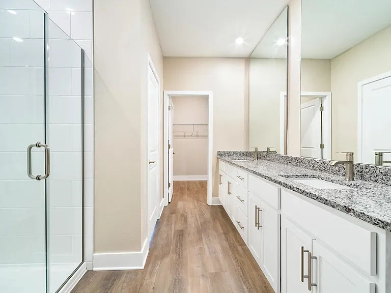 A spacious primary bath at Amavi Kissimmee offers dual vanities with generous storage and thoughtful design.