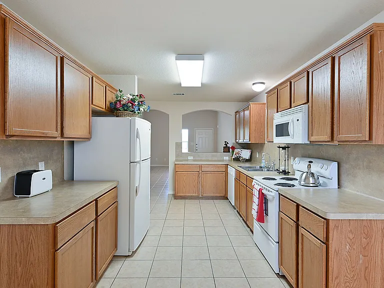 The kitchen is fully equipped with a dishwasher, garbage disposal, built in microwave, refrigerator, electric oven range, fridge, pantry