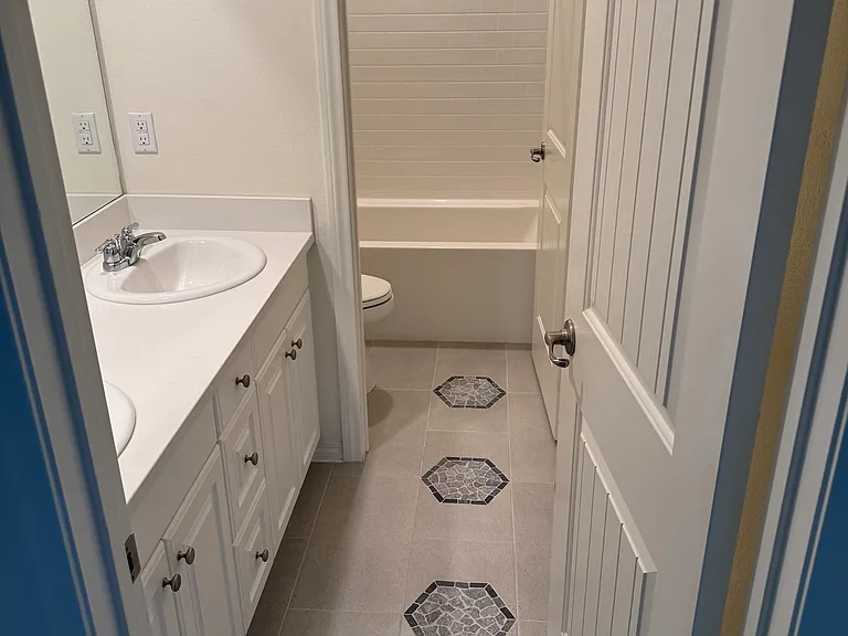 View of upstairs bathroom with two (2) sinks, with lockable door to tub/shower combo and toilet.

New, upgraded tile flooring.
