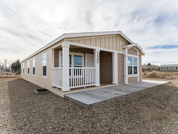 Nice covered deck, concrete walk around to large side patio!  Great for BBQ or hanging outside. 2x6 construction, upgraded insulation, Low-E vinyl windows.  Ground set with concrete block foundation.
