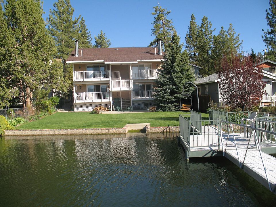 Serene backyard showing 4 private patios, and a pier dock patio located over the lake when lake level is highest. In the background is an original ski chair swing.