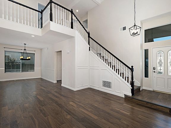 Livingroom with two story high ceiling and beautiful chandelier in the dinning room.