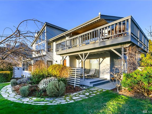View standing in the back yard showing the great outdoor living space.  Upper view deck is partially covered,and accessed off the kitchen area.  Down stairs covered deck is accessed off the master bedroom or sun room.  Imagine a relaxing evening enjoying the beautiful back yard. Lots of color pops up in the Spring! 