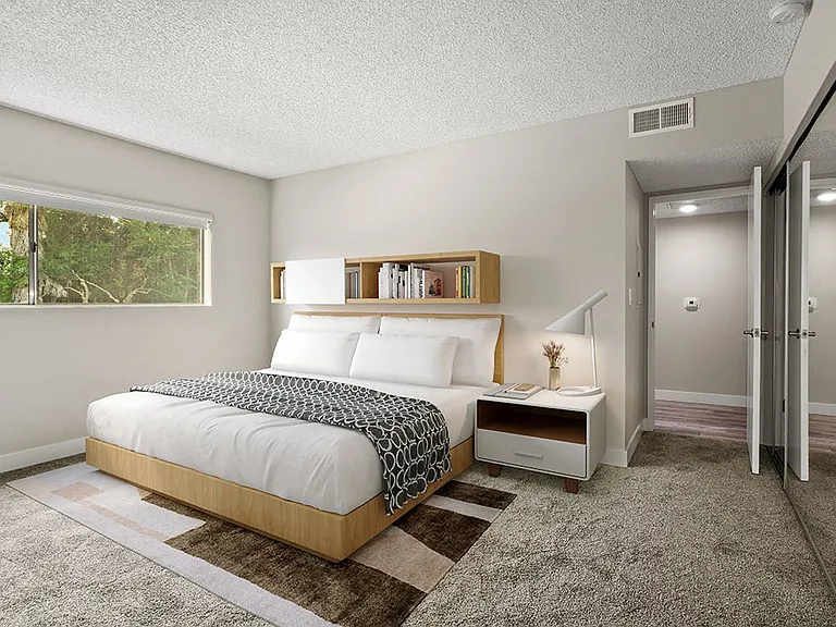 Carpeted bedroom with large window for natural light.