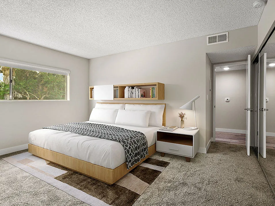 Carpeted bedroom with large window for natural light.