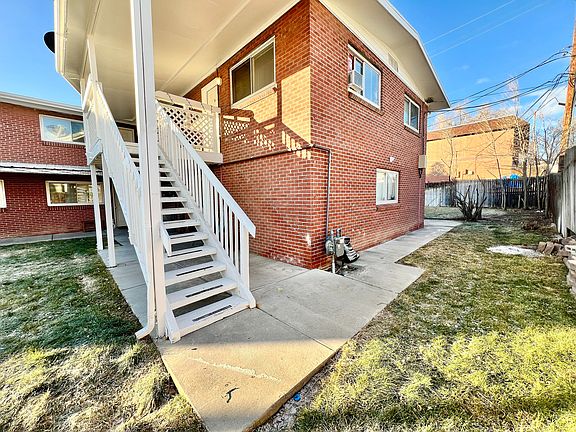 Explore this inviting brick apartment with its charming outdoor staircase, perfect for easy access and style.