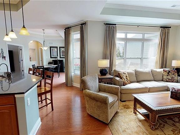 Hardwood flooring throughout most of the main living area is highlighted by the abundance of natural light from the many windows