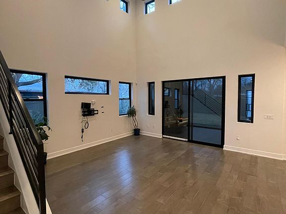 Family room with sliding patio door, lots of windows for natural light, and two-story ceiling.