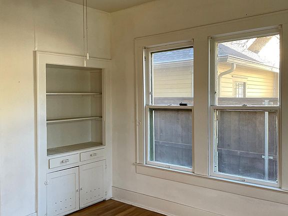 Front bedroom with 2 walls of windows and built-in shelving & storage.