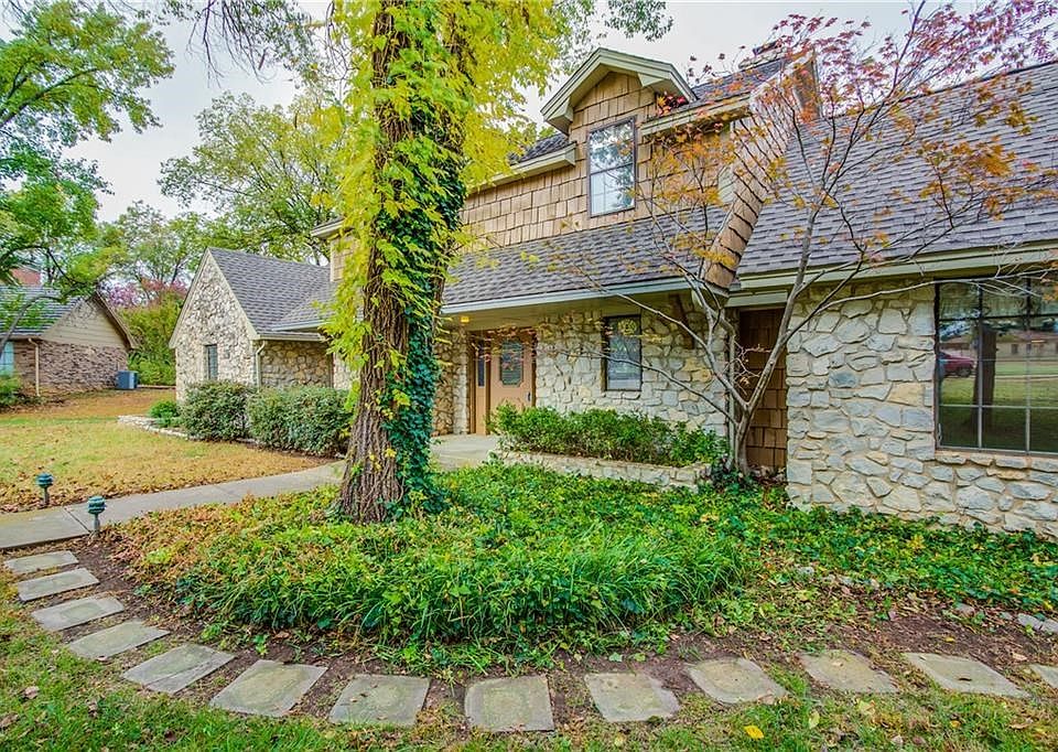 Complementary landscaping with exterior lighting and pathway to side driveway/garage to the front door.