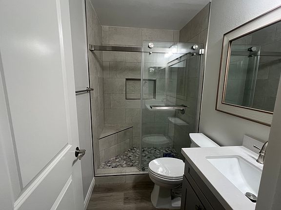 Master bath with tile shower, built-in seat, glass enclosure, all new fixtures and cabinet, framed mirror, medicine cabinet.