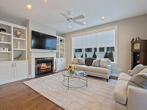 Custom White Built-ins Flank the Marble Surround Fireplace