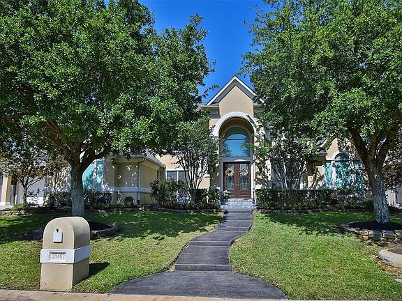 This home is adorned with a lush landscape both front and back.