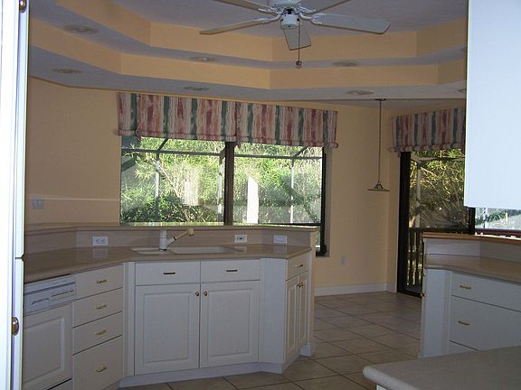 Kitchen with wood cabinetry, sub-zero and Corian counters.