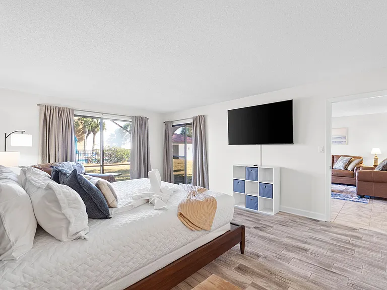 The King Master Bedroom has a patio door to the outside, an ensuite bathroom, and a television.