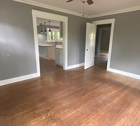 Living room with entry to dining room (left) and hallway to bedrooms.