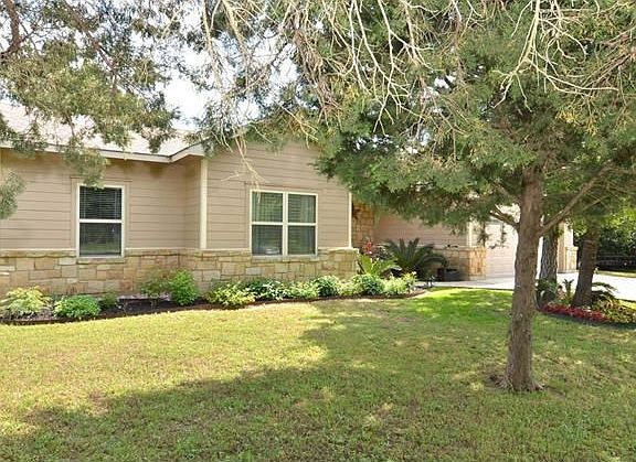 Spacious front yard has a nice mix of trees for shade