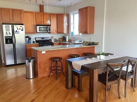 Kitchen with stainless steel appliances, granite counters and a dining room area.
