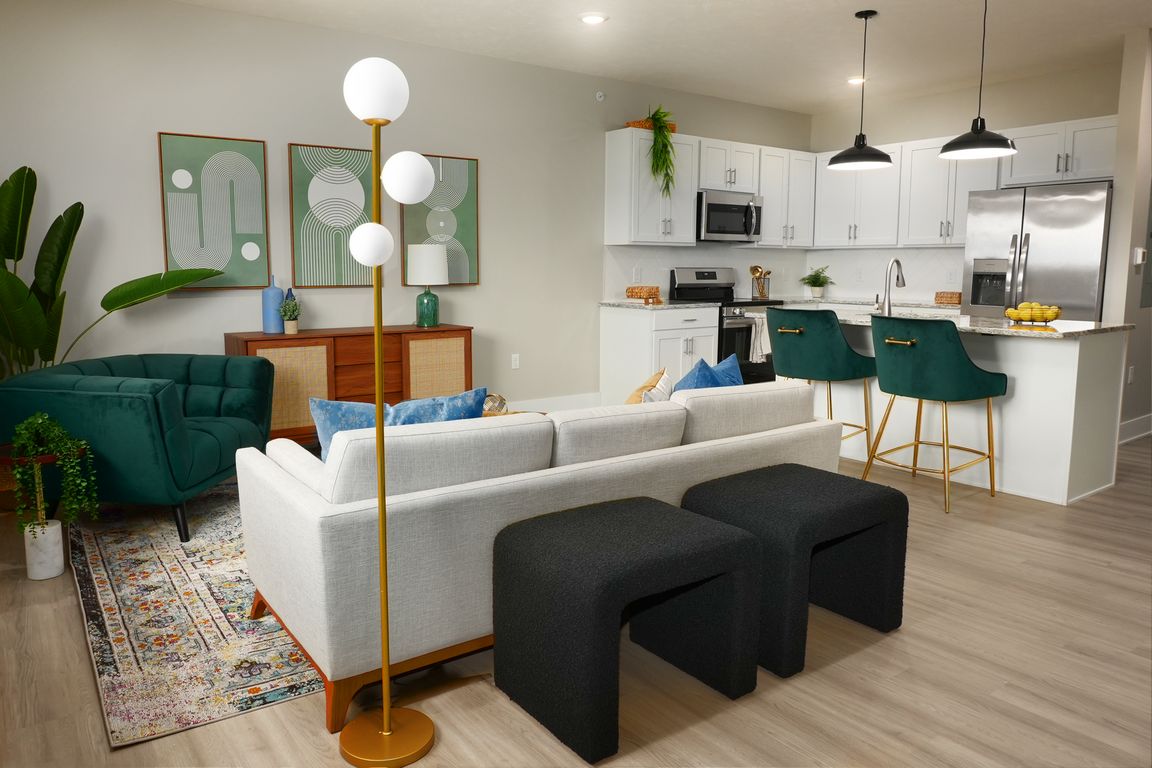 Spacious living room with hardwood flooring along side the kitchen