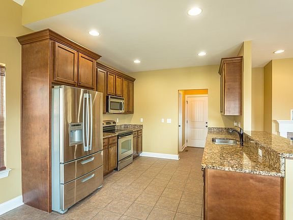 Kitchen w granite and stainless steel appliances.
