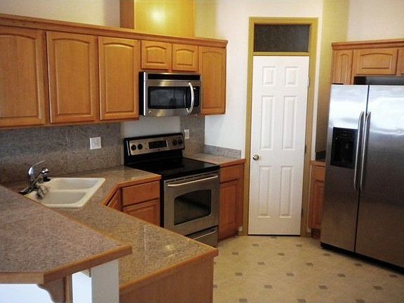 Your open kitchen has stainless steel appliances, granite tiled counters and a walk-in pantry.