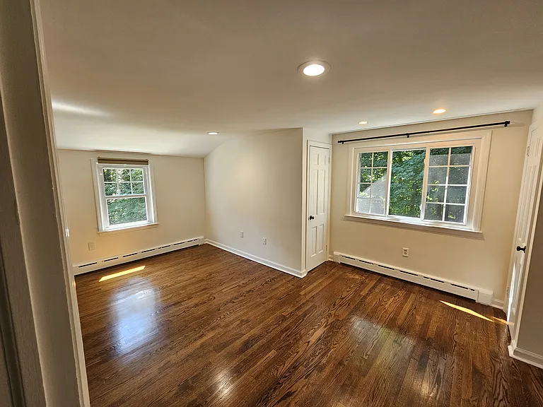 1st Floor Bedroom 2 _ View 1
Bedroom with hardwood floors, recessed lighting, natural light, and direct access to a walk-in closet.