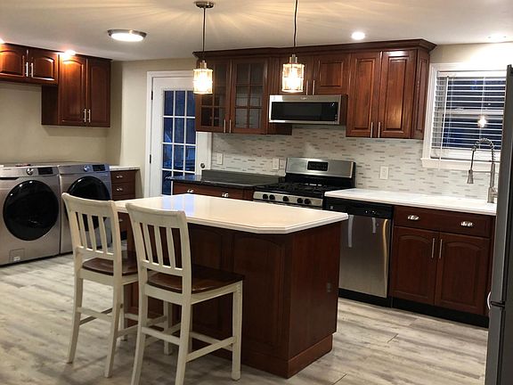 Lots of cabinets and an island with pendant lights