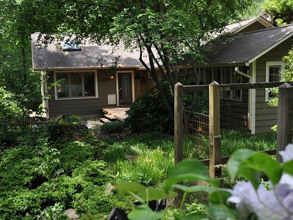 View of front porch and side with handcrafted stone chimney