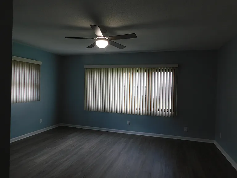 Leaving the family room heading south, we arrive at a hallway leading to the 15.7' x 13.8' master bedroom. Here we have another ceiling fan, this time with a light fixture. We're facing west.