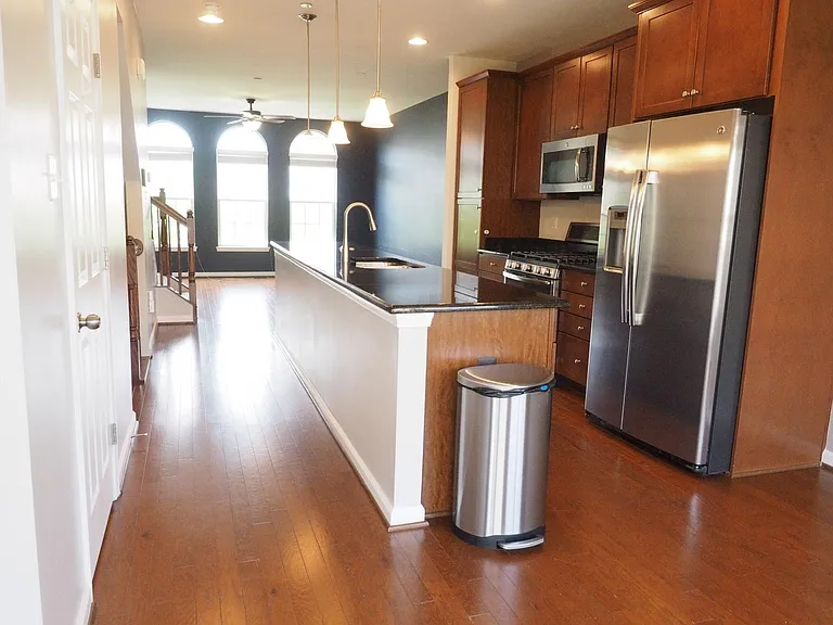 Beautiful wood floors and cabinetry, looking from dining area past kitchen toward living area on front of house.
