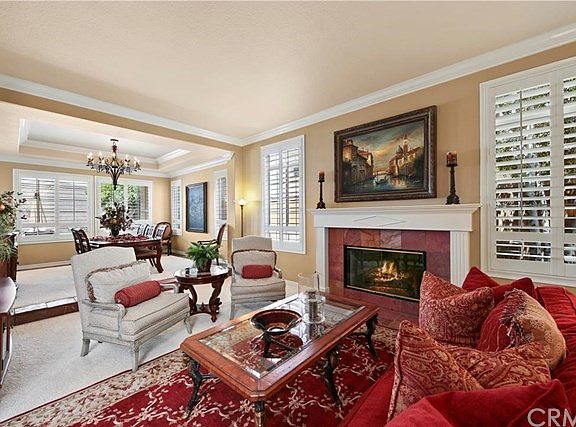 This picture shows the fireplace in the Living with Plantation shutters, and Coffered ceiling in the dining room.