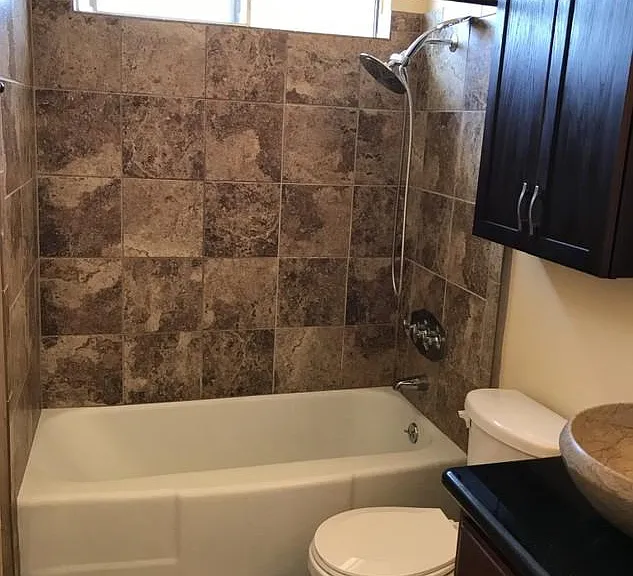 New remodeled bathroom shower stone tile with large shower-head