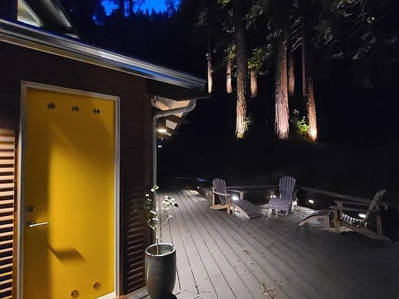 Exterior view, front door and up-lighting for redwood trees.