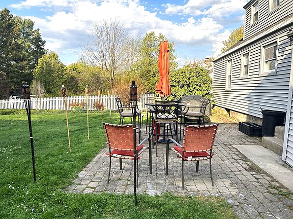 Patio with table, umbrella and chairs.