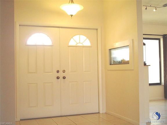 Double SunBurst Doors into Large Tiled Foyer w/ High Ceiling