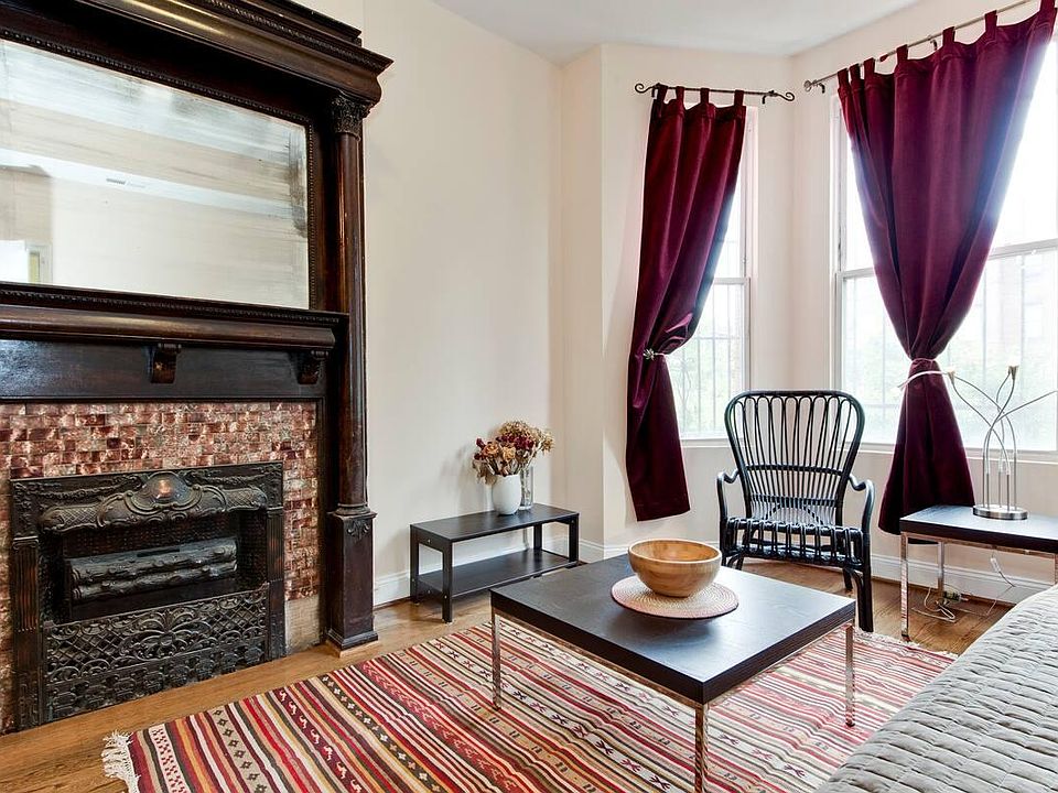Living room with gorgeous antique mantle (not a working fireplace) and lovely hardwood floors.