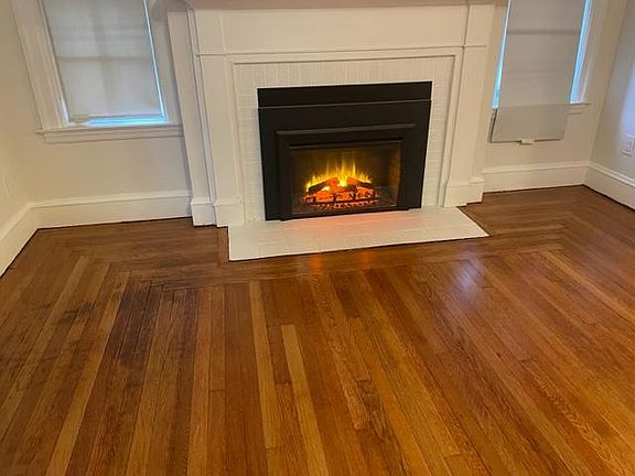 Large oversized living room with a cozy electric fireplace and room for a wide flat screen TV above.