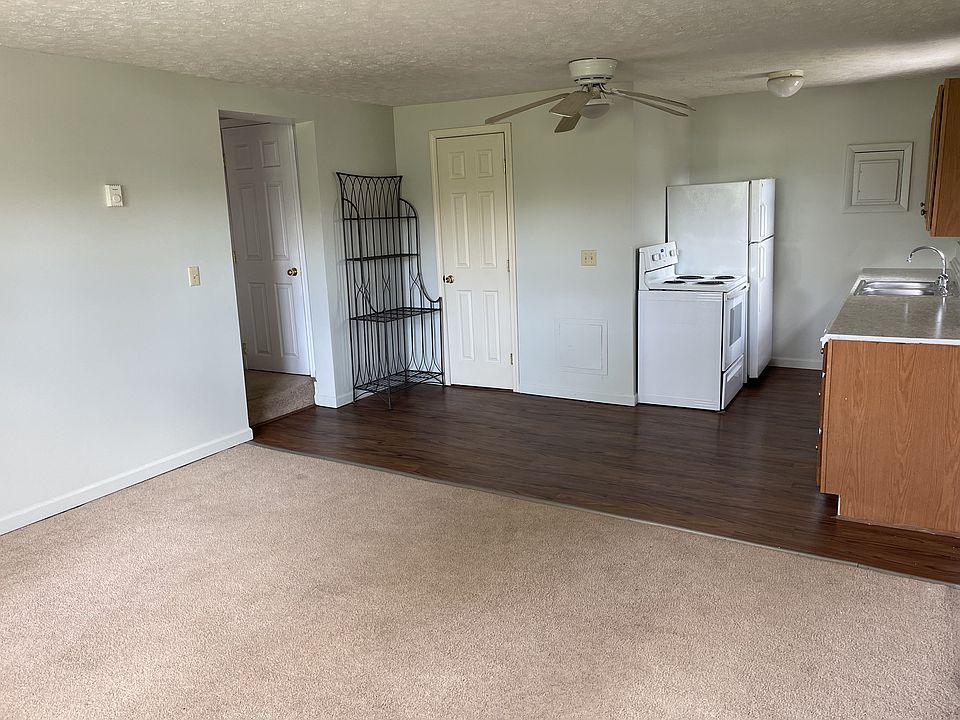 View from living room into kitchen. Closed door is the full bathroom