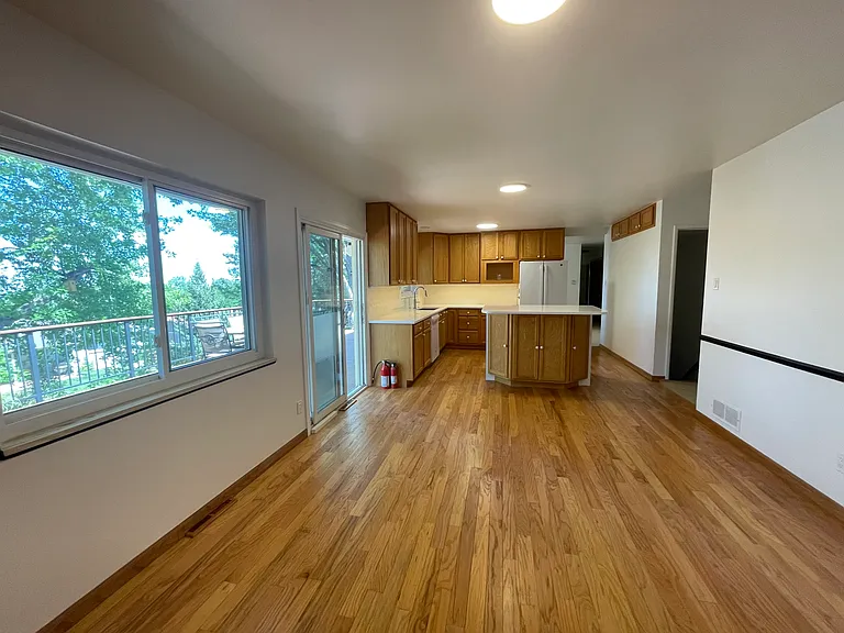 Living room Kitchen area with sliding door to the deck on the left. Doorway and stairs to the right of island to lower walk out basement