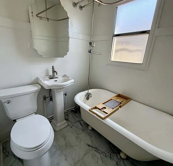 Bathroom includes new sink, new toilet, and refurbished claw foot shower / bathtub.