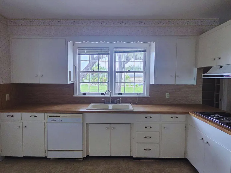 Roomy kitchen with extensive cabinetry and a sun-filled window.