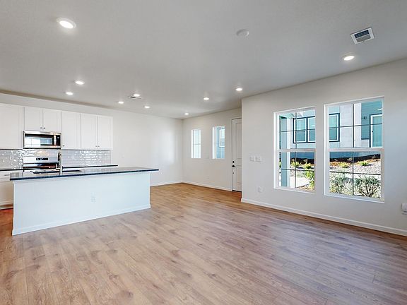 Enter into a bright, open living, dining and kitchen space