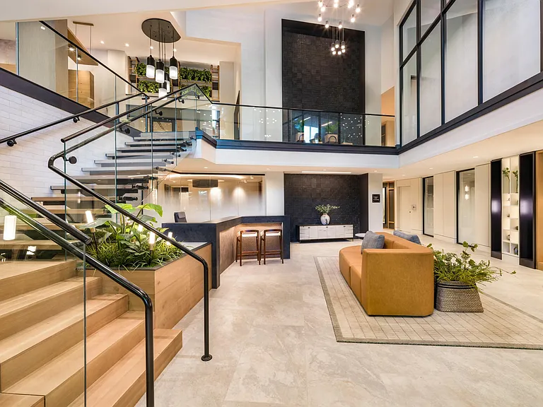 Soaring ceilings, sleek glass railings, and refined finishes welcome you into this sophisticated, light-filled lobby.
