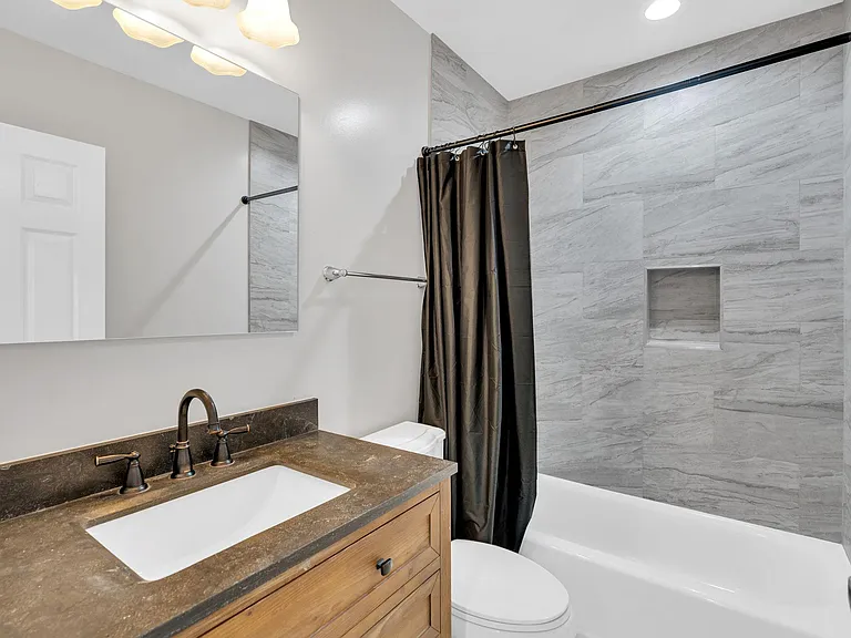 Modern full bathroom featuring a sleek vanity, clean toilet, and stylish tub/toilet combo for your comfort and convenience!