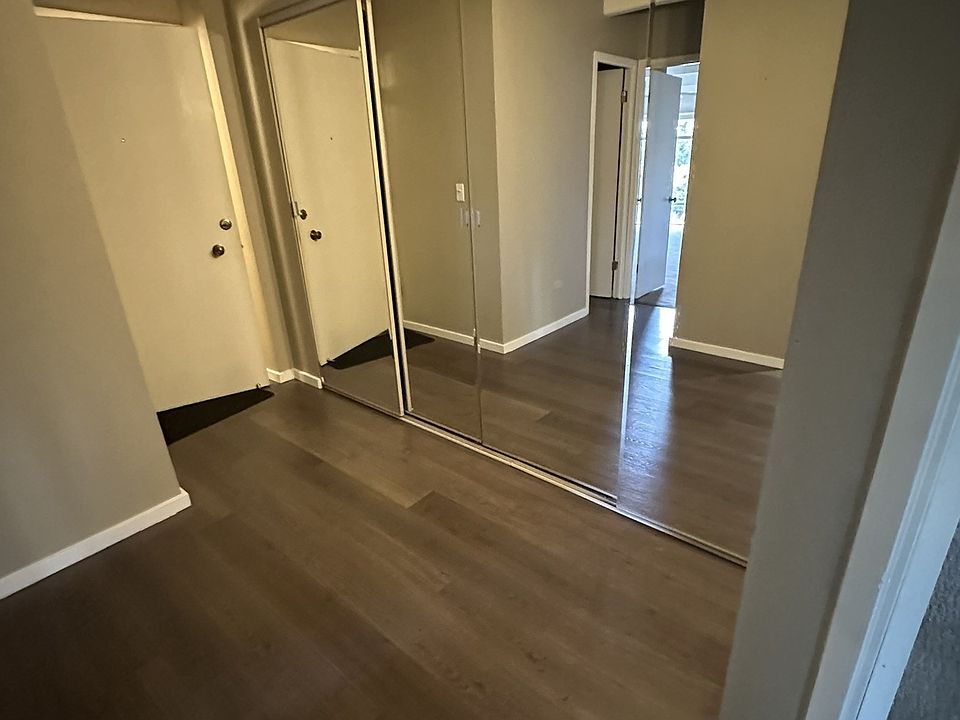 Foyer with mirrored storage closet. Looking toward front door
